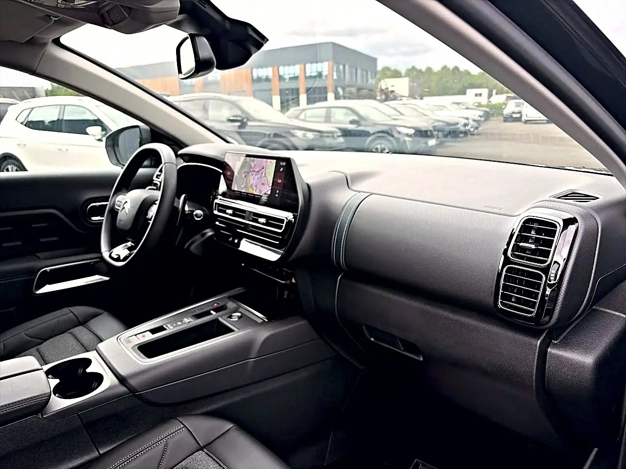 Intérieur noir du Citroën C5 Aircross 2025 vu côté conducteur, avec tableau de bord et écran tactile central.