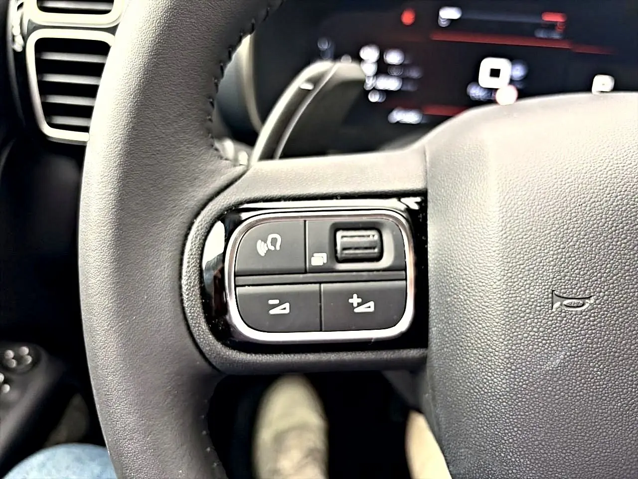 Gros plan sur les commandes au volant cuir noir du Citroën C5 Aircross 2025, côté gauche.