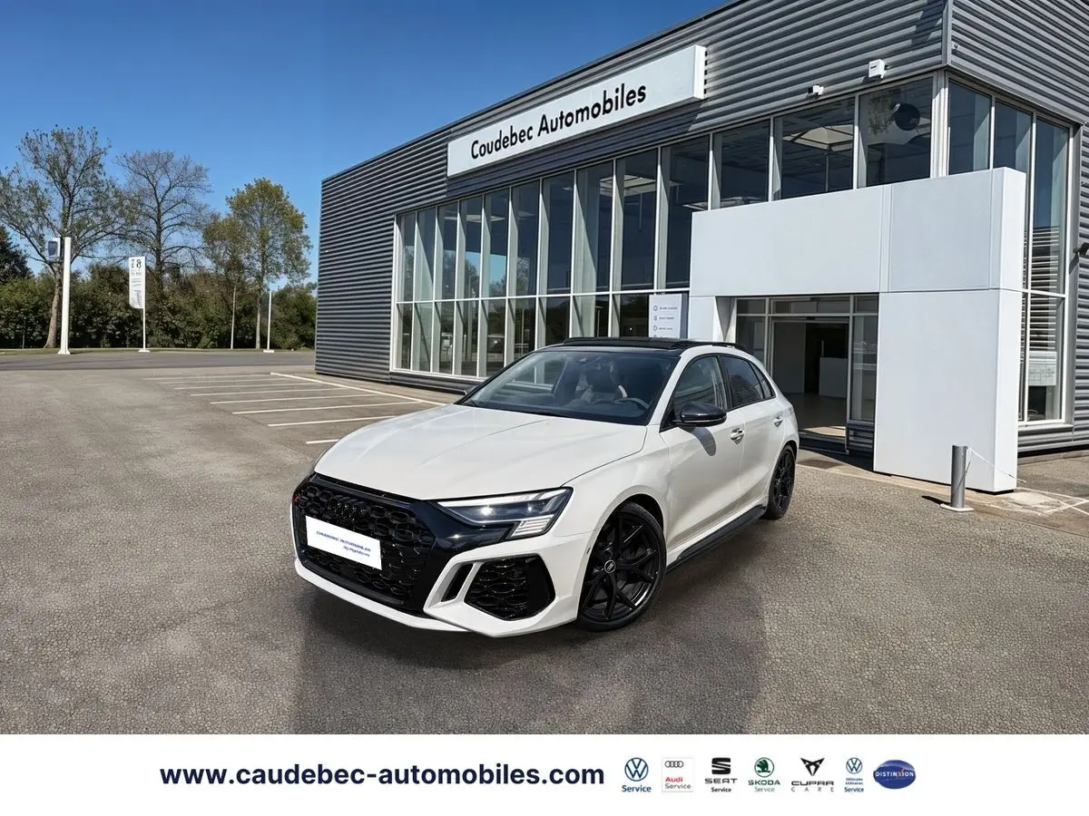 Audi RS3 Sportback gris vue 3/4 avant droit, calandre noire et jantes noires mat devant concession.