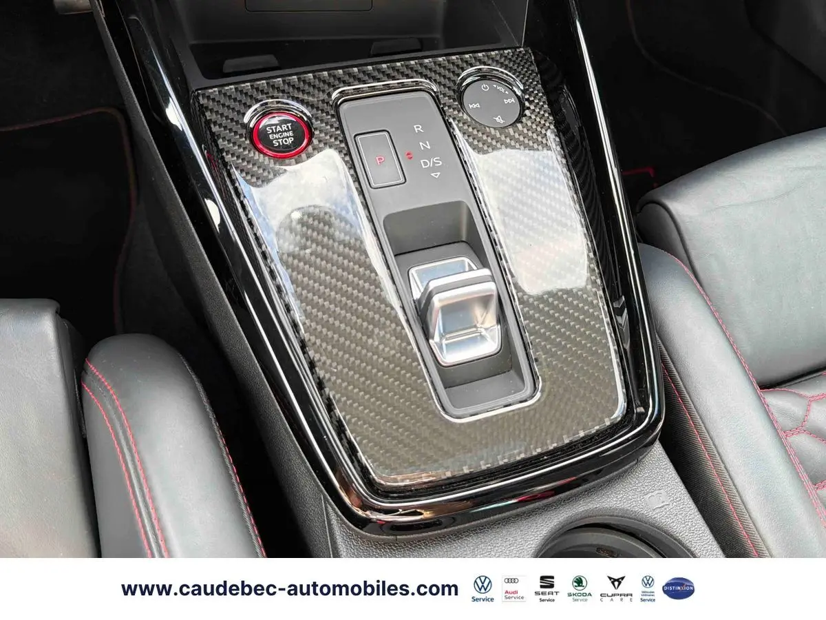 Vue rapprochée de la console centrale en carbone avec bouton Start/Stop rouge et cuir noir surpiqué rouge de l'Audi RS3 Sportback.