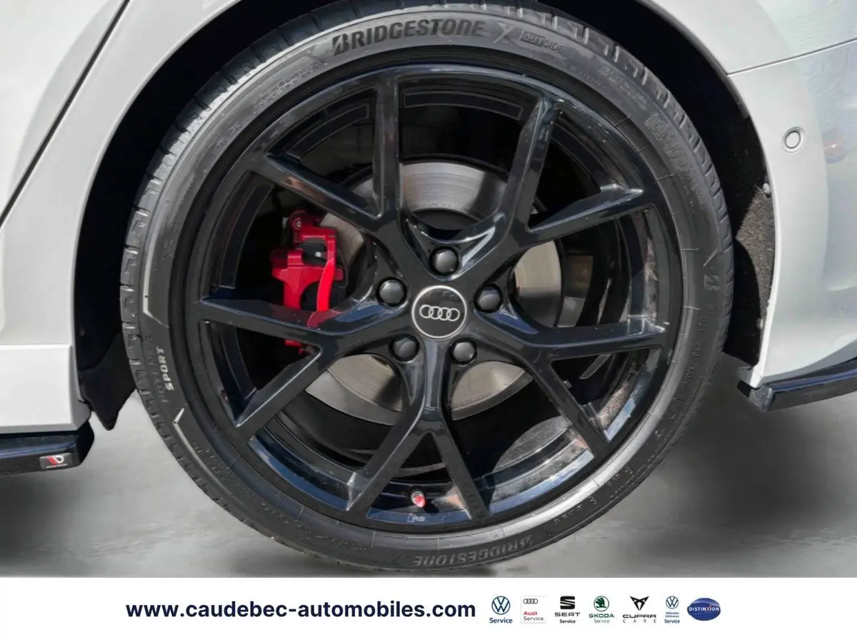 Gros plan sur la jante noire mat à 5 branches en Y avec étrier de frein rouge brillant d’une Audi RS3 Sportback grise.