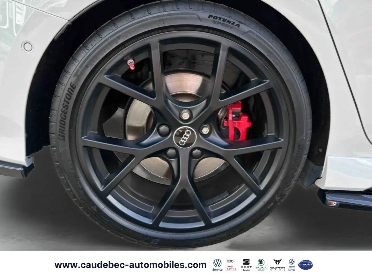 Gros plan sur la jante noire mat à 5 branches en Y de l'Audi RS3 Sportback avec étrier de frein rouge visible.