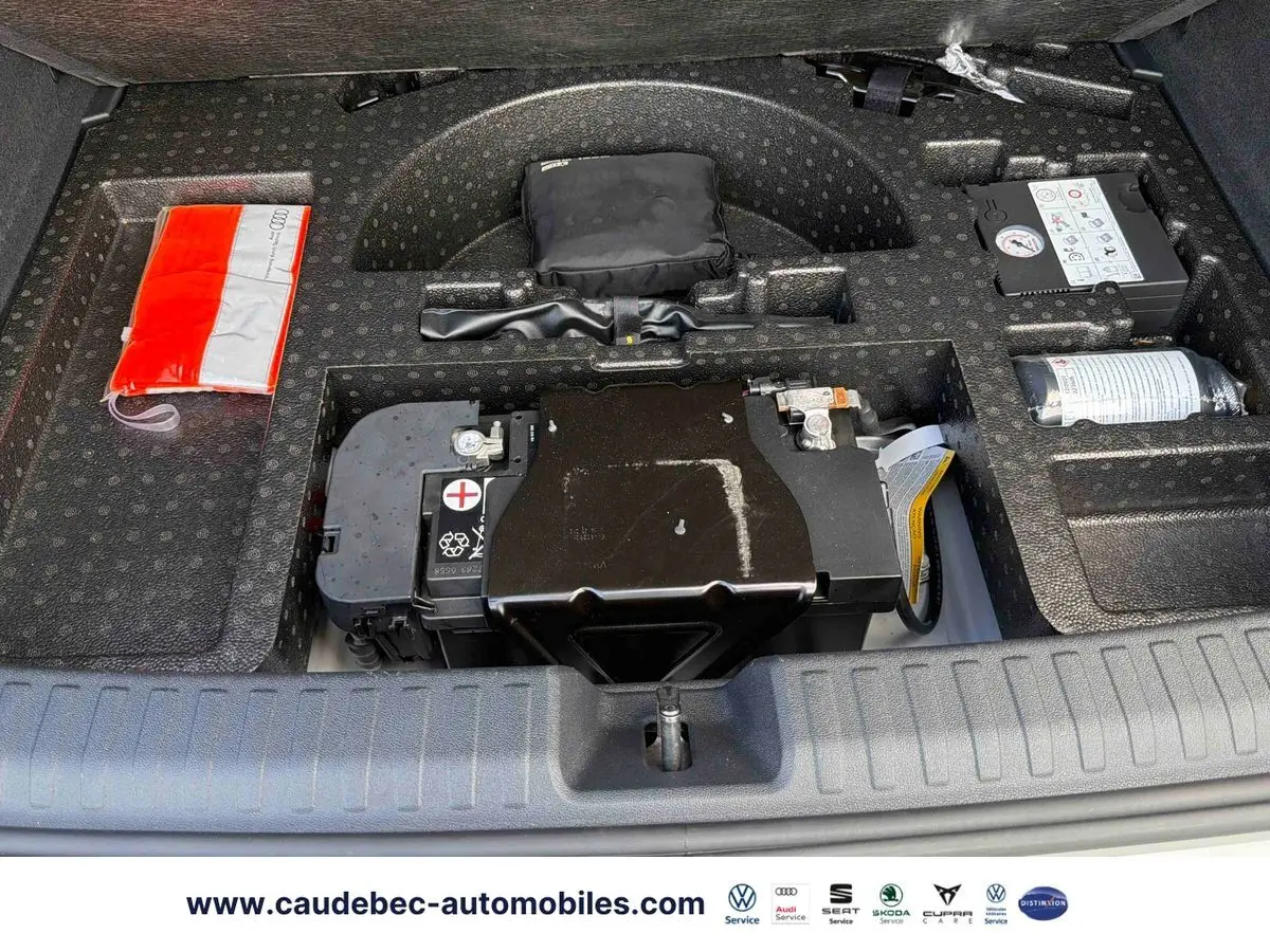 Vue du compartiment sous le coffre de l'Audi RS3 Sportback 2022, montrant la batterie et les outils de bord.