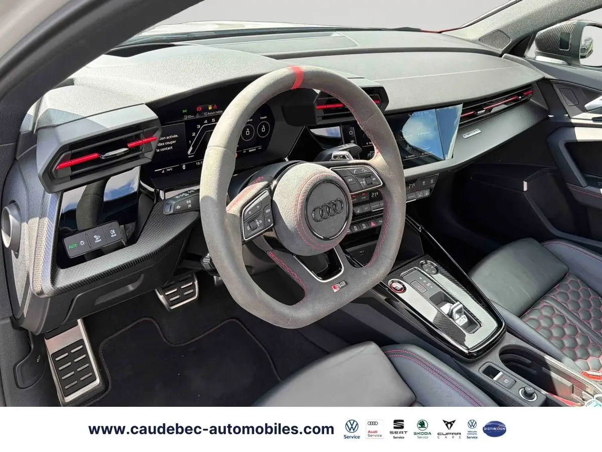 Intérieur Audi RS3 Sportback 2022, vue côté conducteur, volant sport en alcantara avec surpiqûres rouges et tableau de bord numérique.