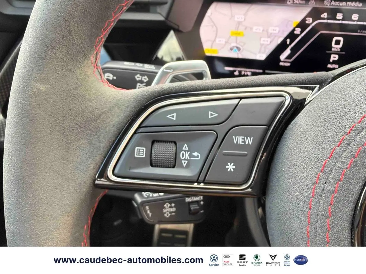 Gros plan sur les commandes du volant en alcantara gris avec surpiqûres rouges de l'Audi RS3 Sportback 2022.
