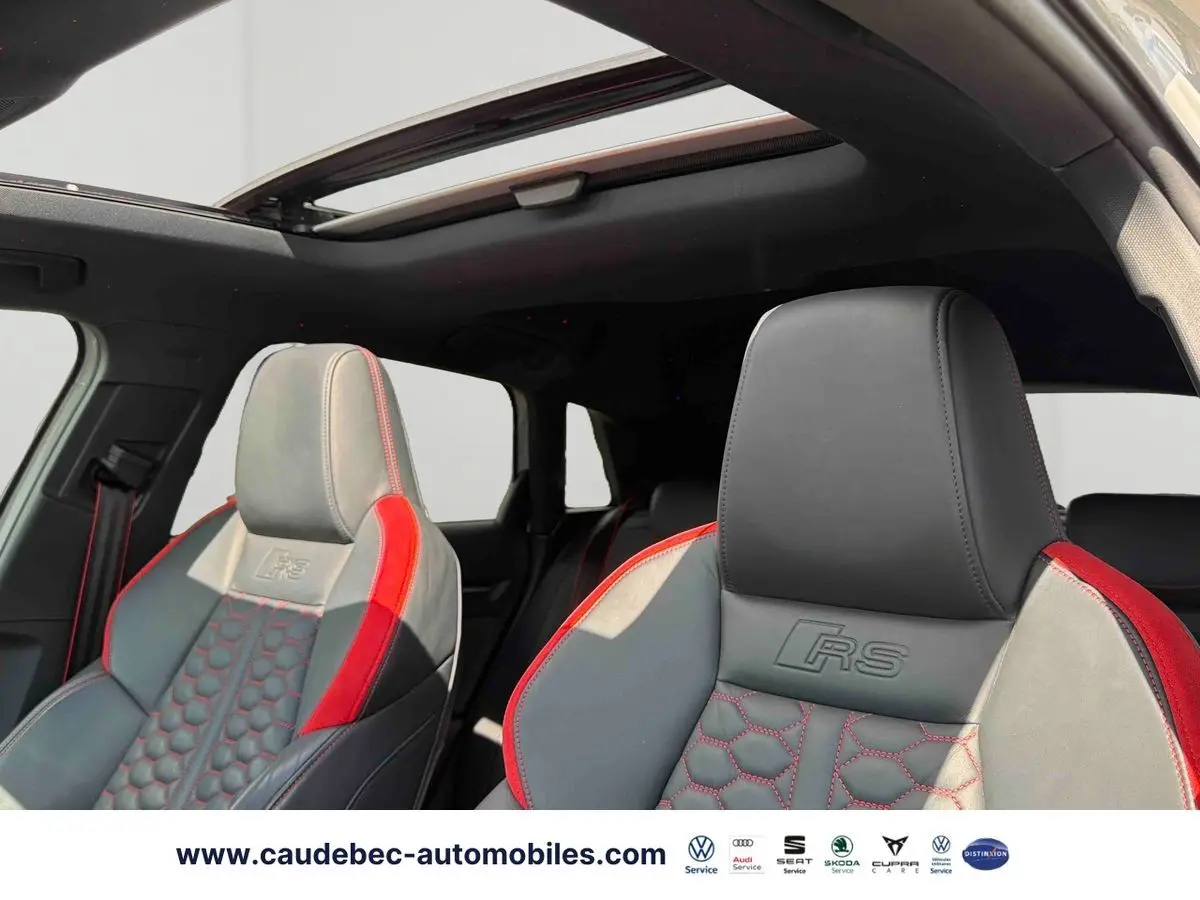 Vue intérieure des sièges avant en cuir gris et rouge avec surpiqûres RS et toit panoramique ouvrant de l'Audi RS3 Sportback.