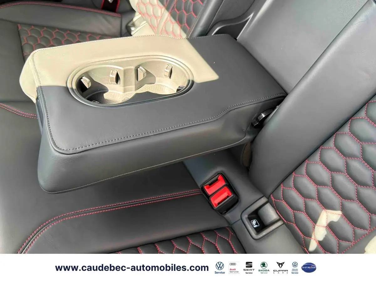 Détail de l'accoudoir central arrière en cuir noir avec surpiqûres rouges sur les sièges de l'Audi RS3 Sportback grise.