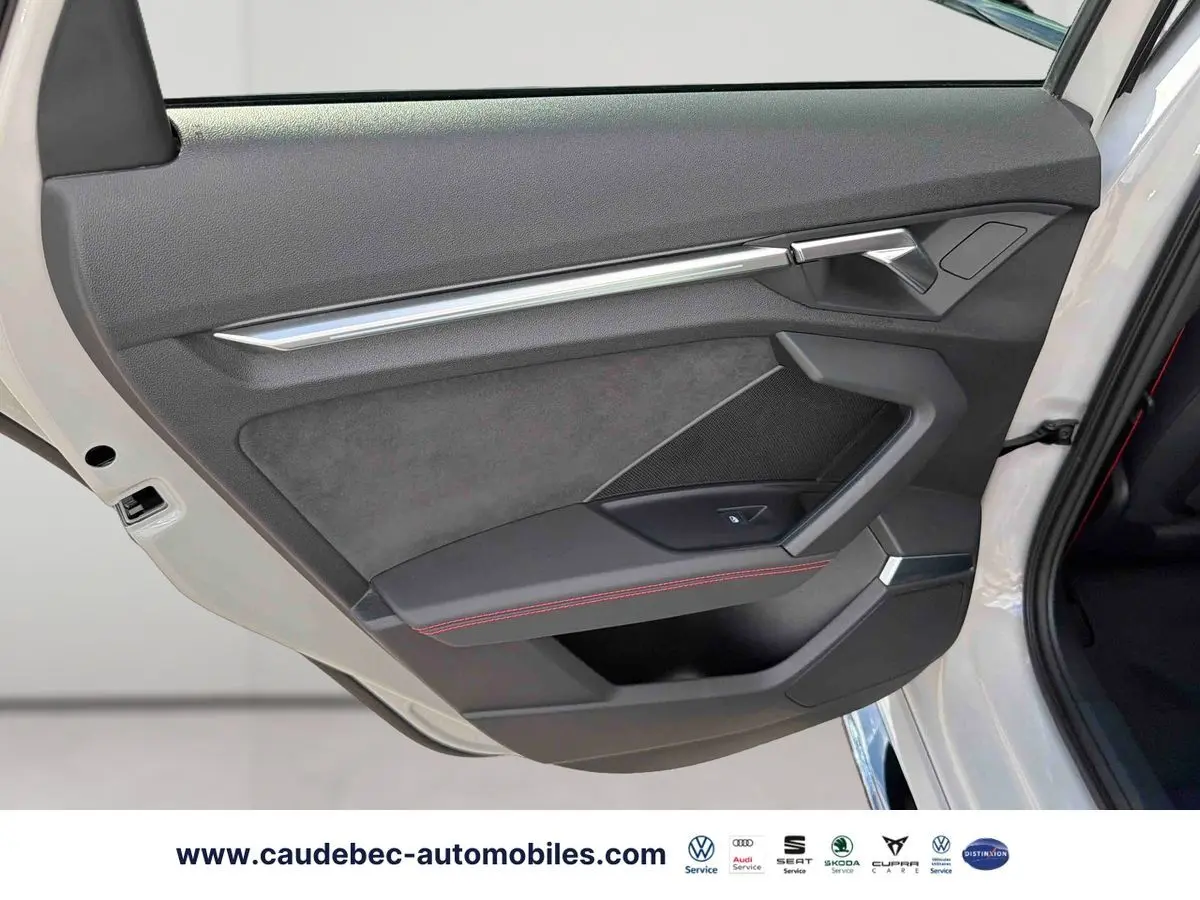 Vue rapprochée de la porte arrière gauche grise de l'Audi RS3 Sportback avec surpiqûres rouges et insert noir mat.