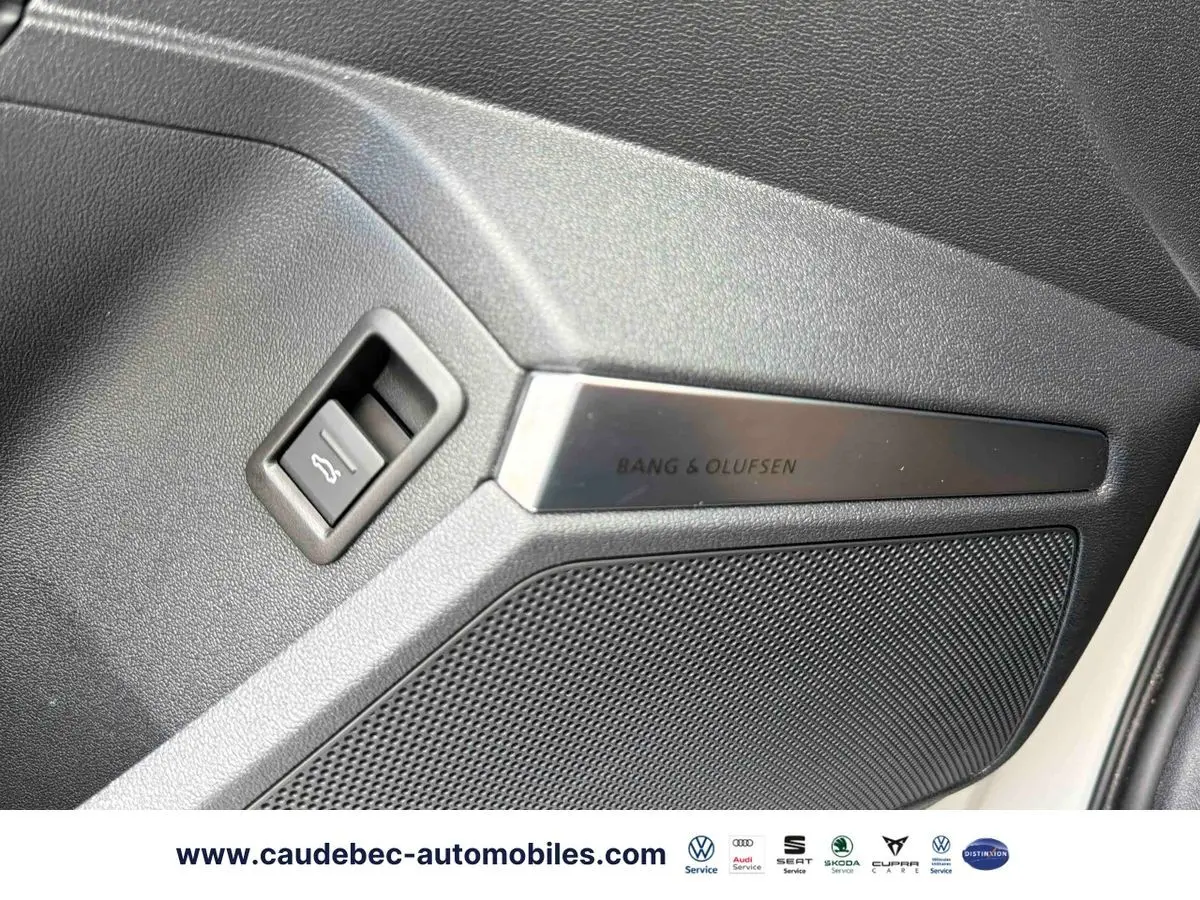 Détail de la porte intérieure droite grise de l'Audi RS3 Sportback avec haut-parleur Bang & Olufsen et bouton d'ouverture de coffre.