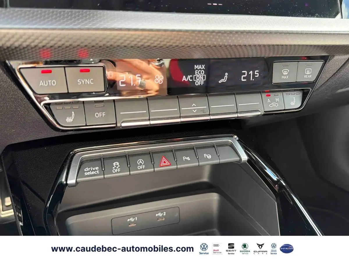Détail du tableau de bord de l’Audi RS3 Sportback 2022 montrant les commandes de climatisation et les boutons multifonctions en noir brillant.