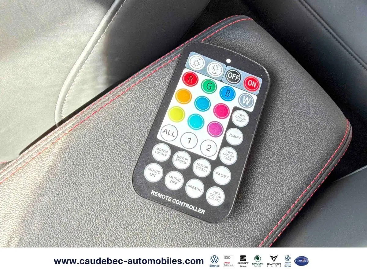 Télécommande d'éclairage multicolore posée sur un accoudoir en cuir noir avec surpiqûres rouges dans l'Audi RS3 Sportback.