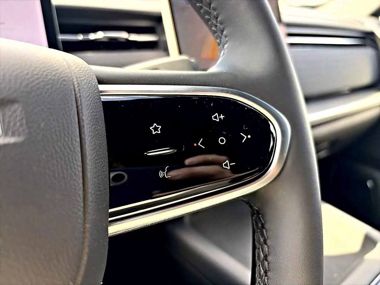 Gros plan sur les commandes multifonctions noires à touches tactiles du volant cuir noir du JAECOO J7 gris moonlight.