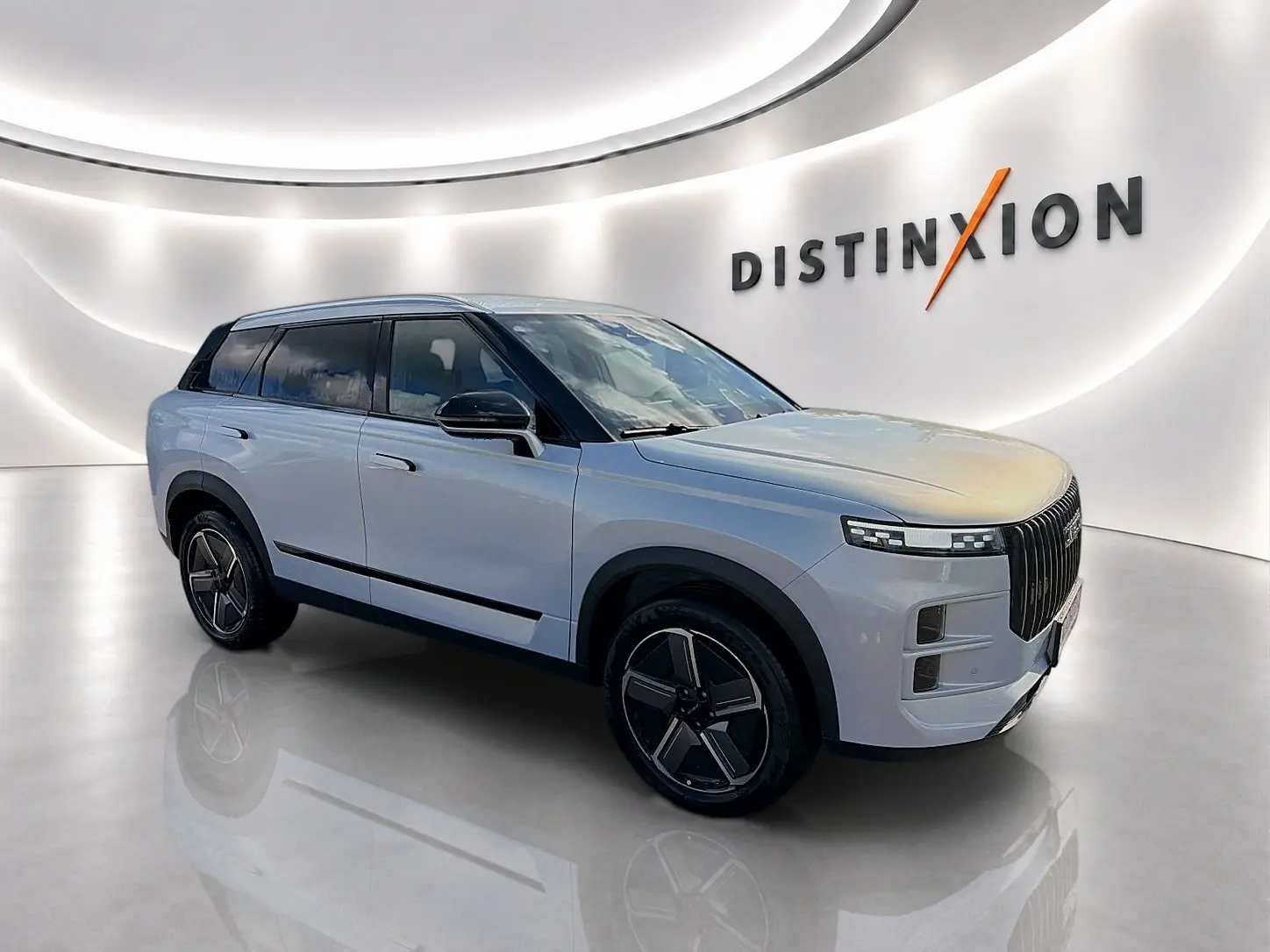 Vue 3/4 avant droit du SUV JAECOO J7 gris moonlight avec calandre verticale et jantes alu noires.