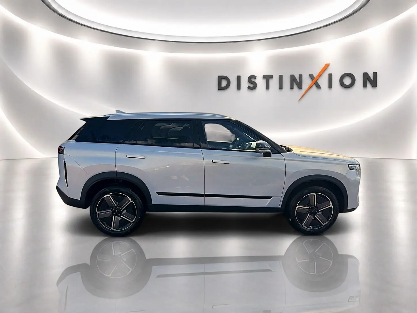 Vue de profil côté gauche du SUV JAECOO J7 gris moonlight avec jantes alu et toit panoramique en studio lumineux.