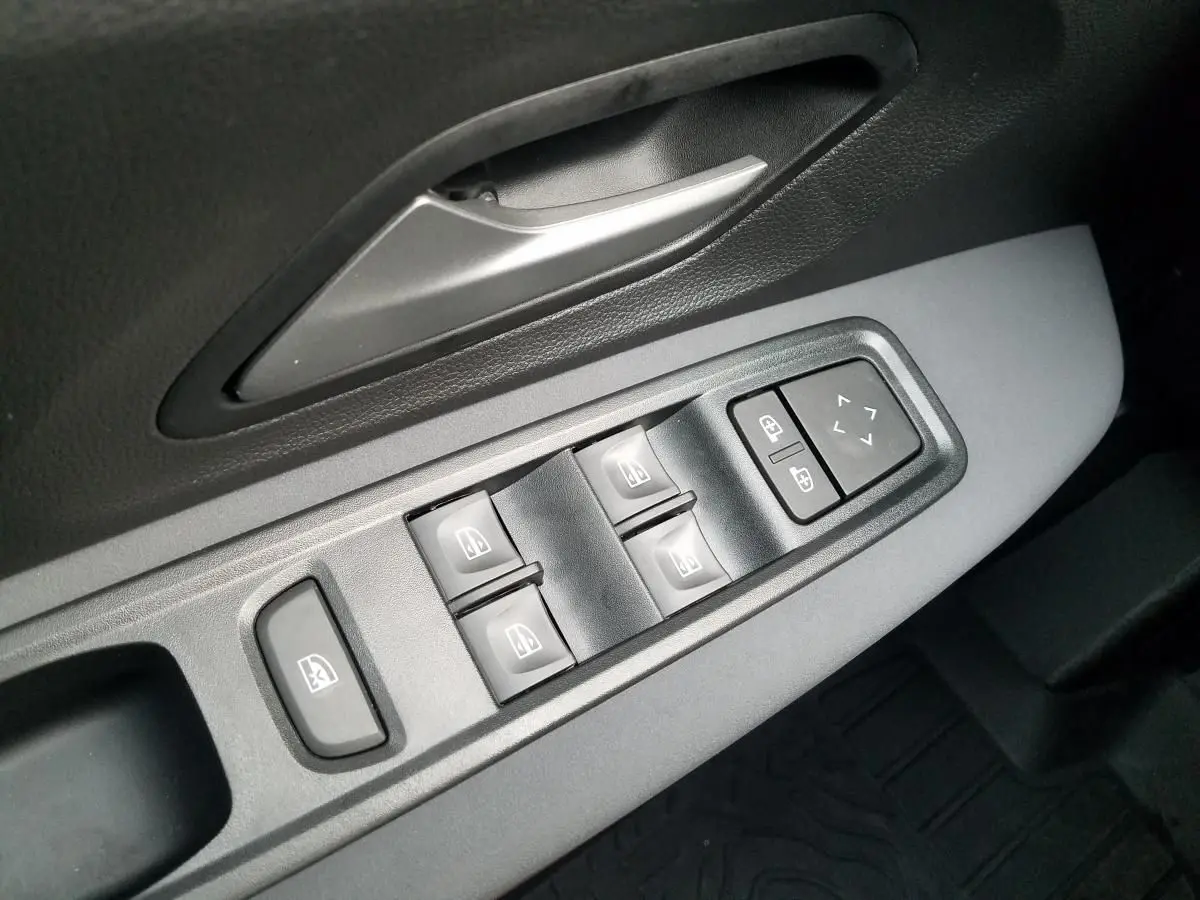 Gros plan sur les commandes électriques des vitres et rétroviseurs côté conducteur du Dacia Jogger 2025 gris urbain.