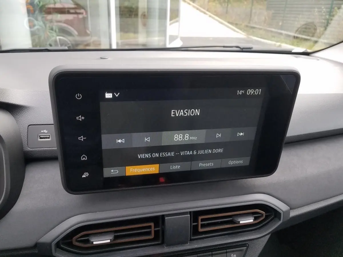 Écran tactile central affichant la radio FM dans l'habitacle gris du Dacia Jogger 2025, version Extreme.
