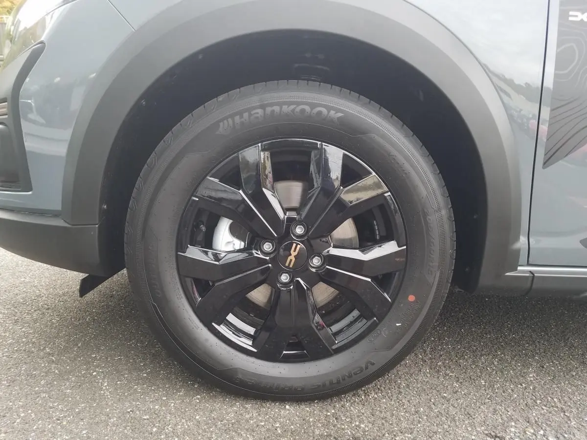 Gros plan sur la roue avant gauche du Dacia Jogger gris urbain, mettant en valeur la jante noire brillante et le pneu Hankook.