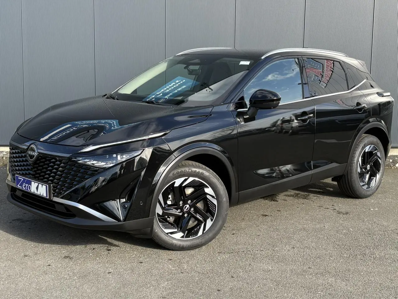 Vue 3/4 avant gauche d'un Nissan Qashqai 2025 noir avec jantes alliage noires et calandre distinctive en losange.