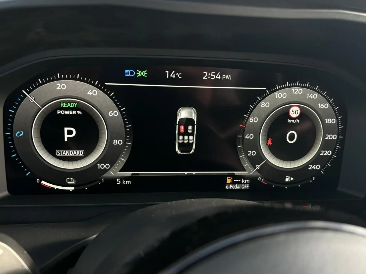 Tableau de bord numérique du Nissan Qashqai 2025, affichage central avec compteurs ronds et alertes visibles.