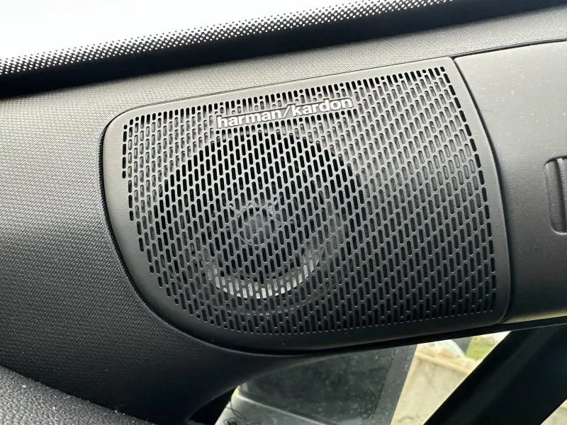 Gros plan sur le haut-parleur Harman Kardon noir intégré dans l'habitacle du Renault Captur 2025 côté gauche.