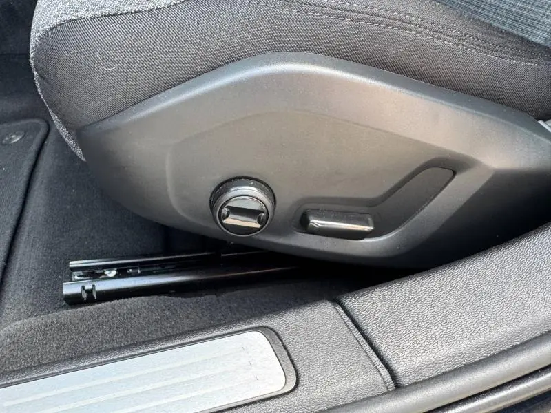 Gros plan sur les commandes de réglage électrique du siège avant droit d'une Volvo S60 2024, intérieur noir.