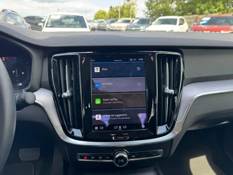 Vue intérieure centrée sur l'écran tactile et la console centrale noire du Volvo S60 2024, avec tableau de bord gris.
