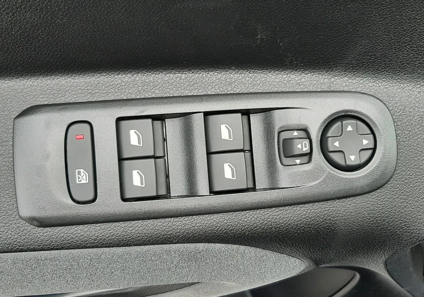 Gros plan sur les commandes de lève-vitres et réglage des rétroviseurs côté conducteur du Peugeot Rifter blanc Kaolin.