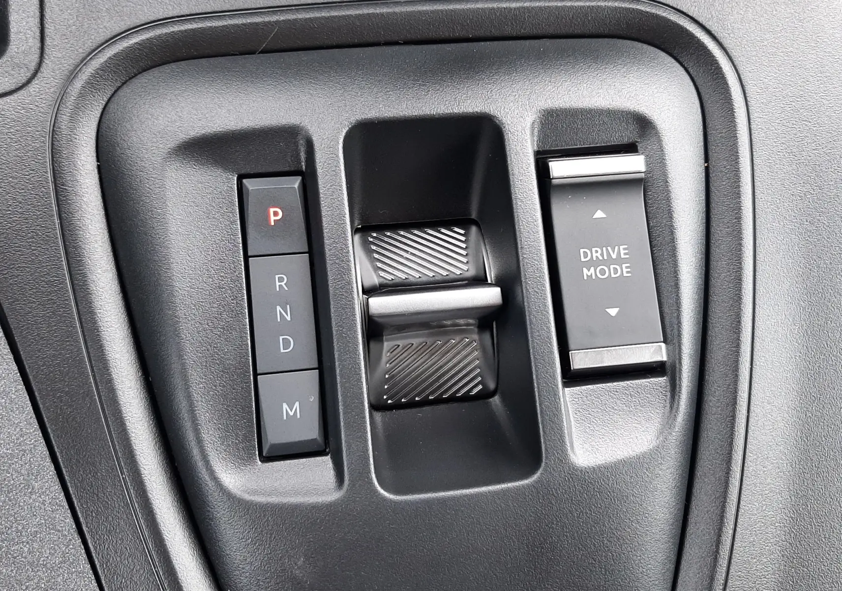 Gros plan sur la commande de boîte automatique et le sélecteur de mode de conduite du Peugeot Rifter blanc Kaolin 2026.