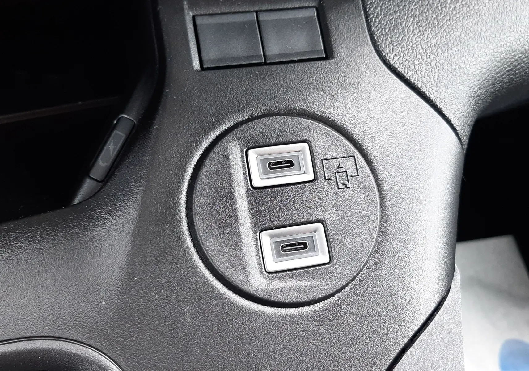 Gros plan sur les ports USB-C doubles intégrés dans la console centrale noire du Peugeot Rifter blanc Kaolin 2026.