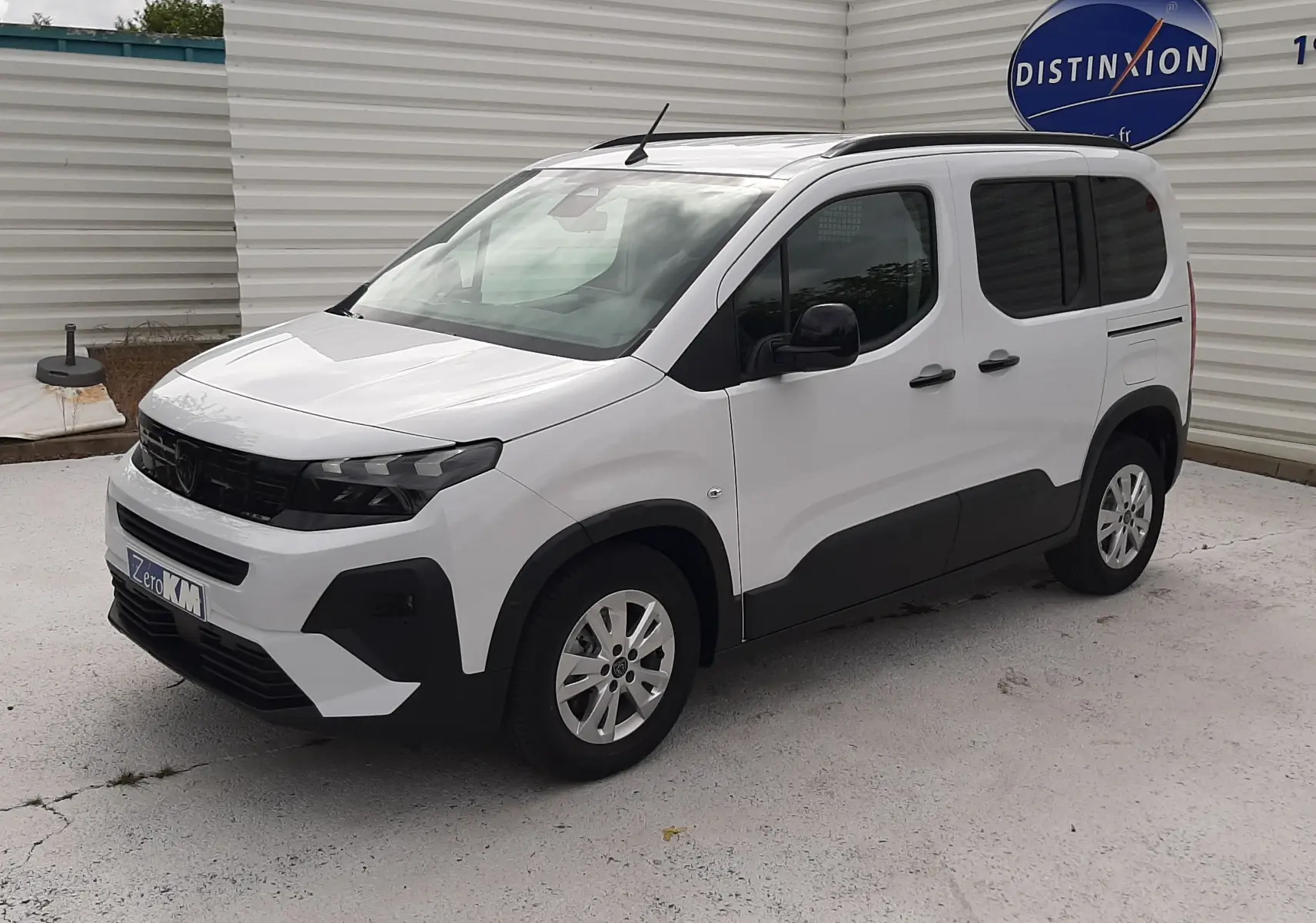 Peugeot Rifter blanc Kaolin vu en 3/4 avant droit, avec protections noires sur les bas de caisse et jantes alliage 16 pouces.