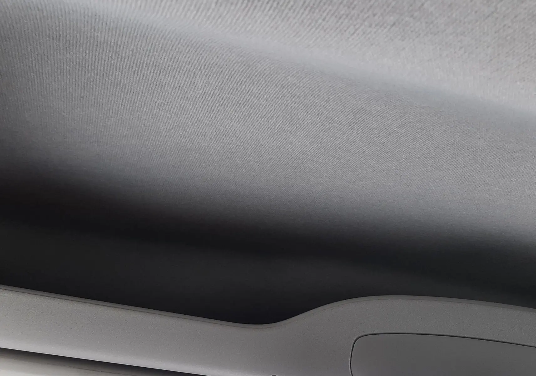 Plafond intérieur gris clair du Peugeot Rifter blanc Kaolin, vue en contre-plongée vers l'avant avec miroir intérieur visible.