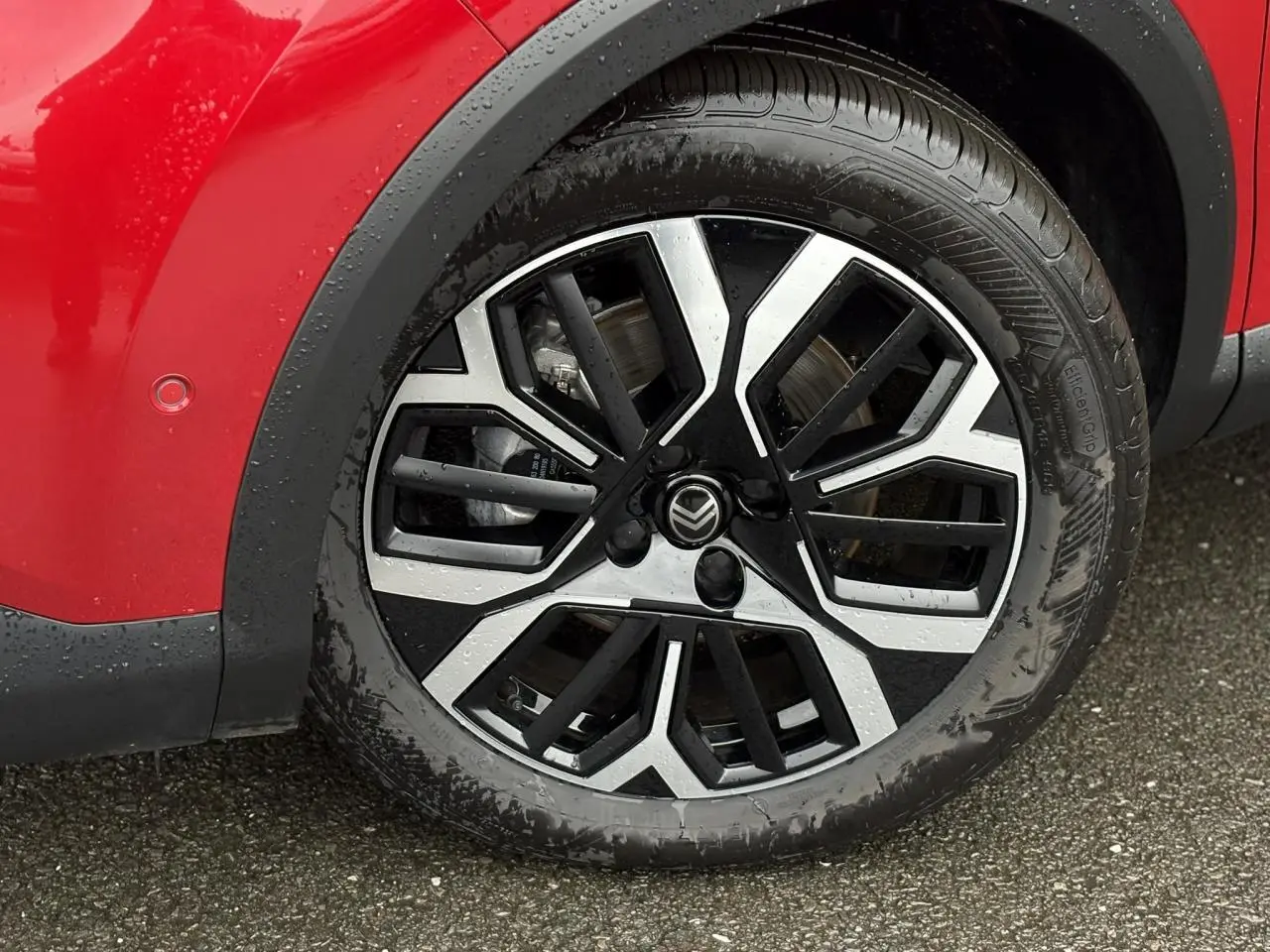 Gros plan sur la roue avant gauche de la Citroën C4 Rouge Elixir avec jante alliage diamantée noire et argentée.