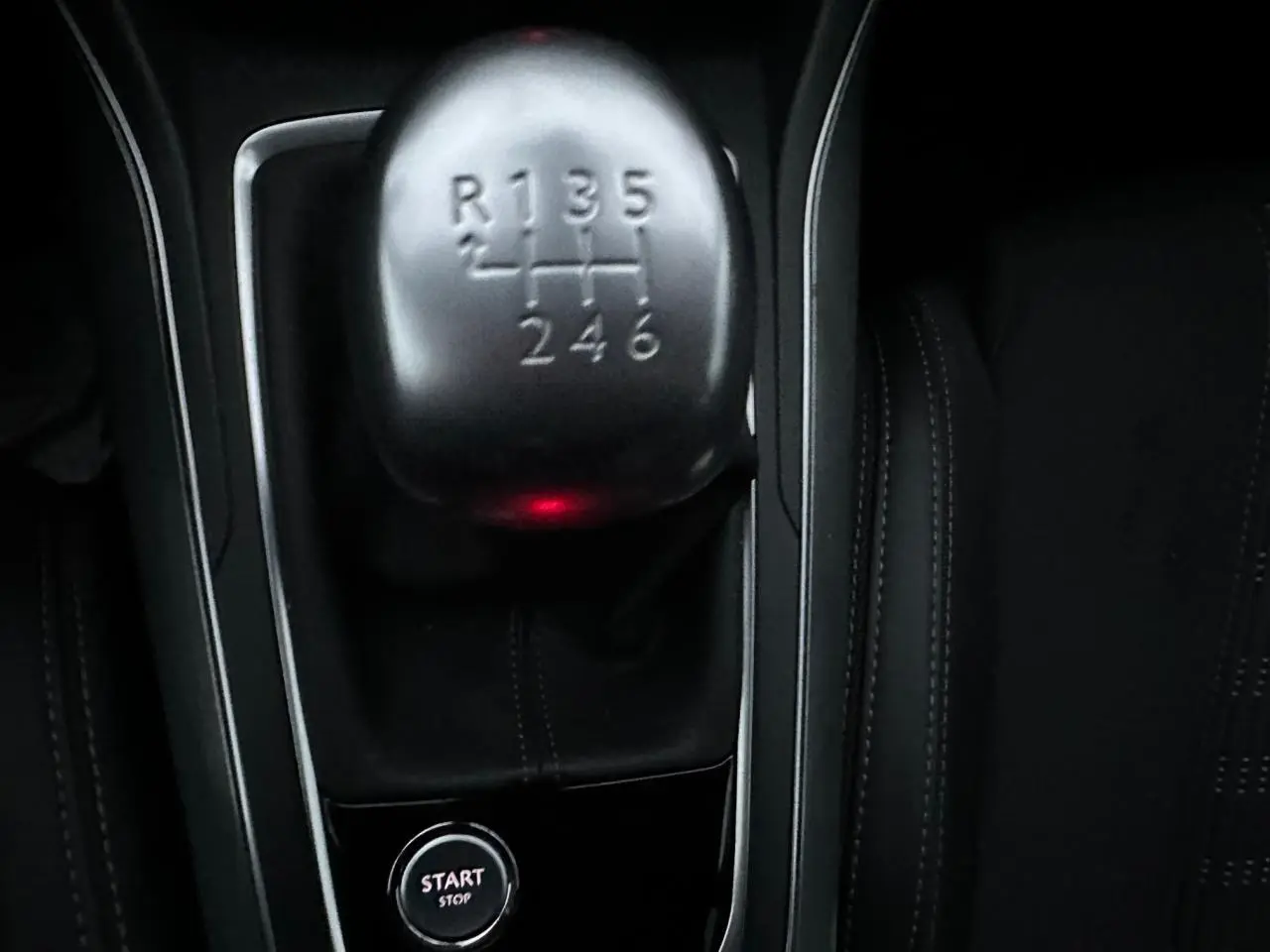 Gros plan sur le levier de vitesses manuel et le bouton start/stop, intérieur noir de la Peugeot 308 Gris Artense.