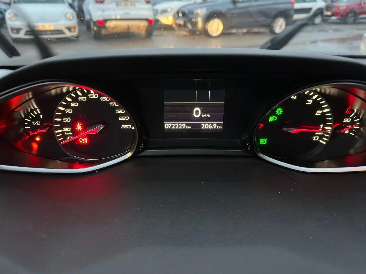 Vue rapprochée du tableau de bord numérique de la Peugeot 308 gris Artense, affichant 72 229 km et témoins allumés.