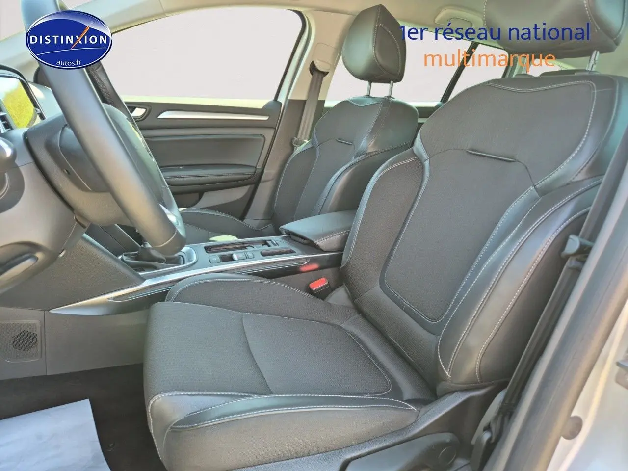 Vue intérieure côté avant droit de la Renault Mégane Break 2024, sièges tissu gris foncé avec coutures contrastées.