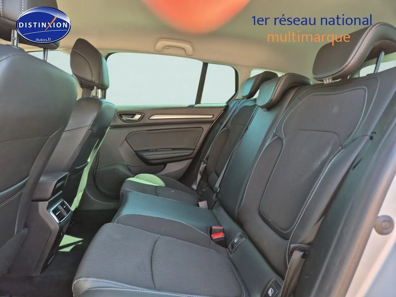 Vue intérieure arrière de la Renault Mégane Break 2024 montrant la banquette tissu gris foncé avec appuie-têtes et ceintures de sécurité.