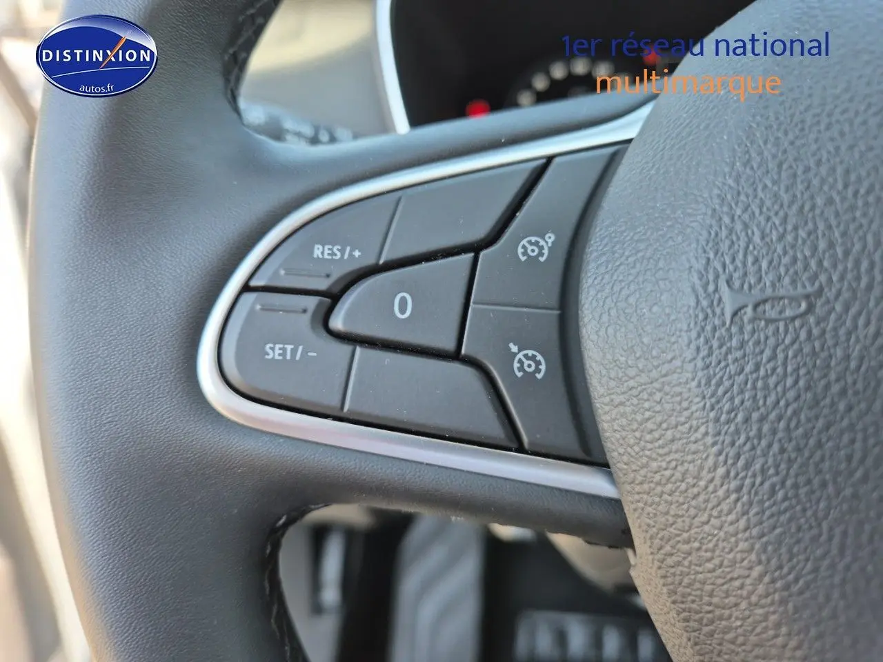 Gros plan sur les commandes de régulateur de vitesse au volant noir du Renault Mégane Break Gris Titanium 2024.