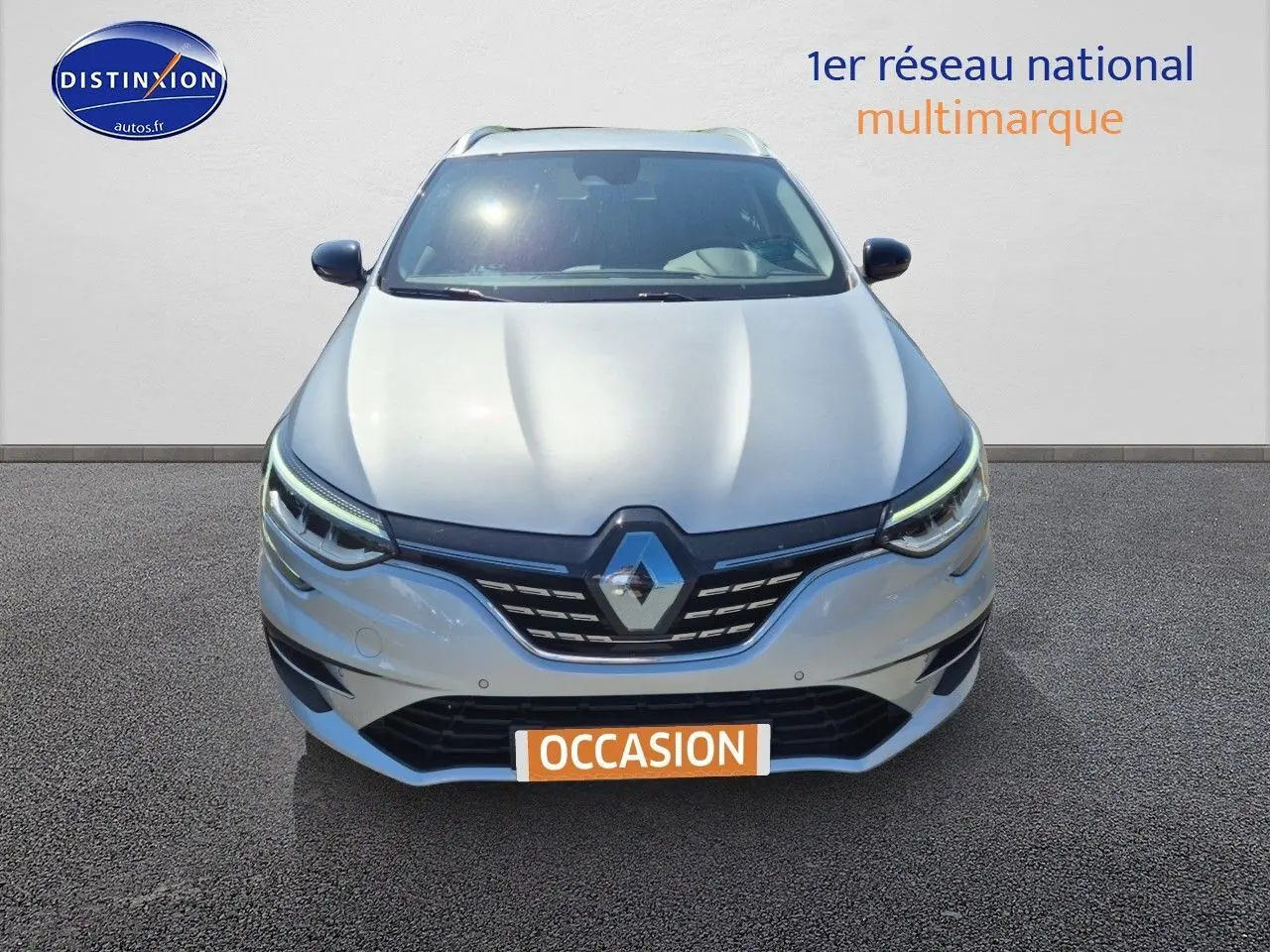 Vue frontale d'une Renault Mégane Break gris Titanium 2024 avec phares LED et calandre noire distinctive.