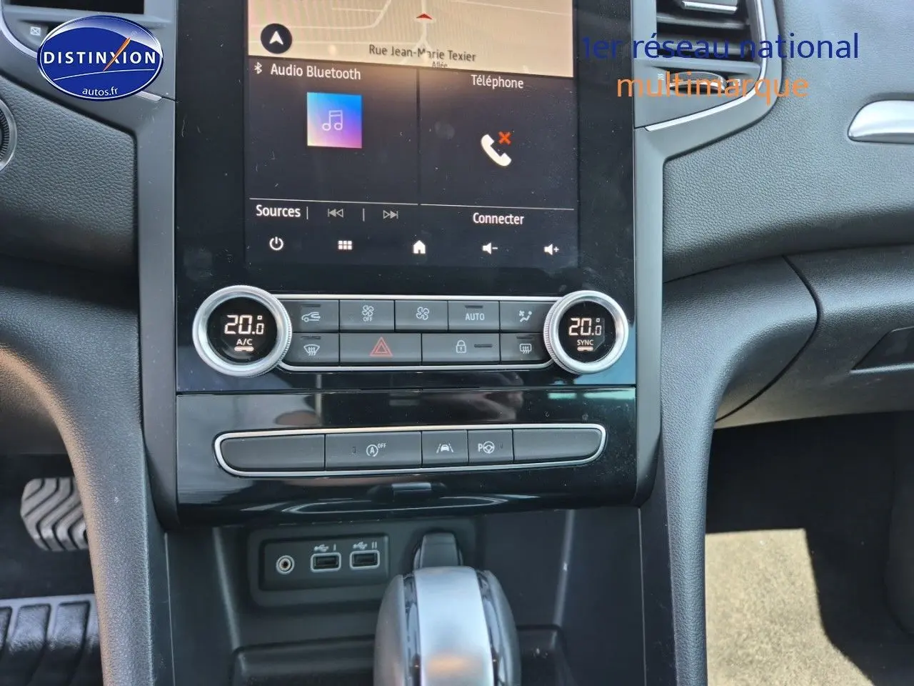 Vue rapprochée de la console centrale de la Renault Mégane Break 2024 gris Titanium, avec écran tactile et commandes climatisation.