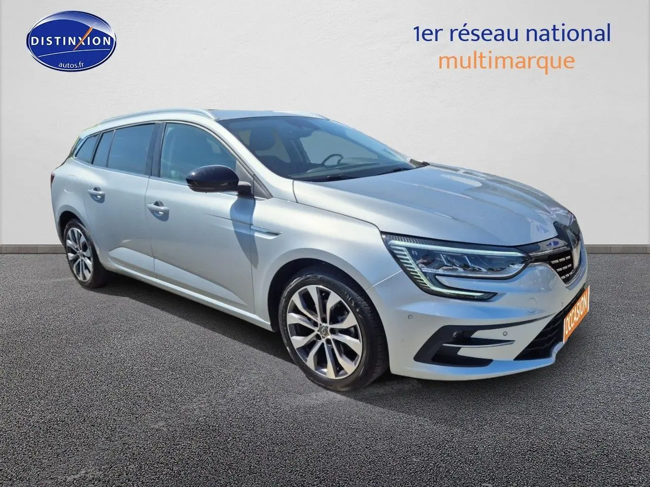 Renault Mégane Break gris titanium vue 3/4 avant droit avec jantes alliage et barres de toit.