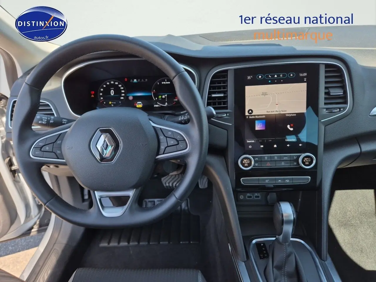 Vue intérieure centrée sur le volant multifonction et l’écran tactile du tableau de bord de la Renault Mégane Break gris Titanium.