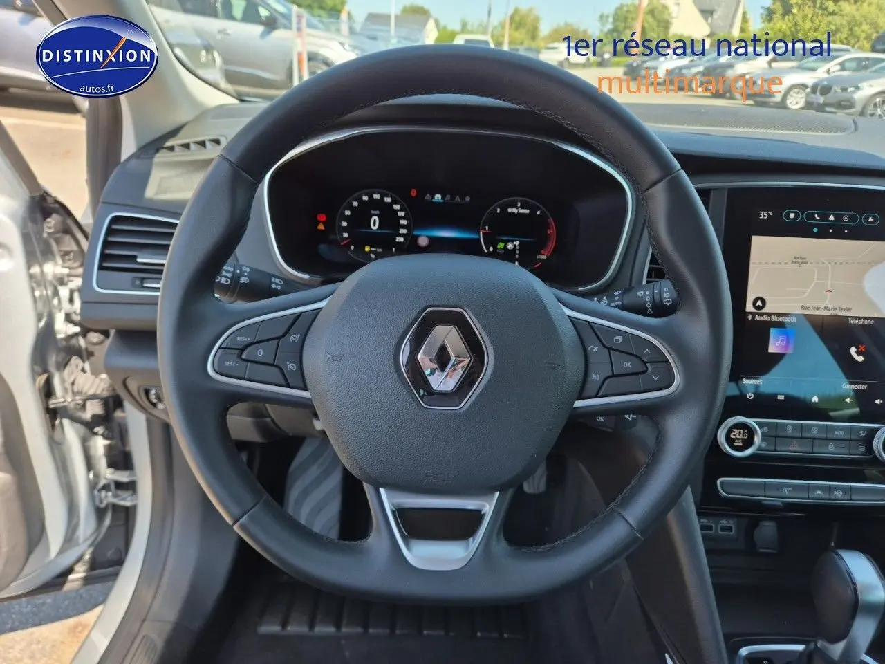 Vue centrée sur le volant multifonction noir du Renault Mégane Break 2024 avec tableau de bord digital et écran tactile.