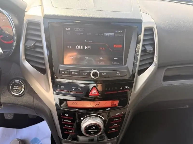 Vue rapprochée du tableau de bord du SsangYong Tivoli blanc 2017, avec écran central et commandes climatisation visibles.