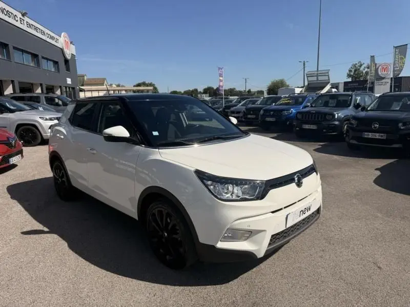 Vue 3/4 avant droite d'un SsangYong Tivoli blanc bi-ton avec toit noir et jantes noires, stationné en extérieur.