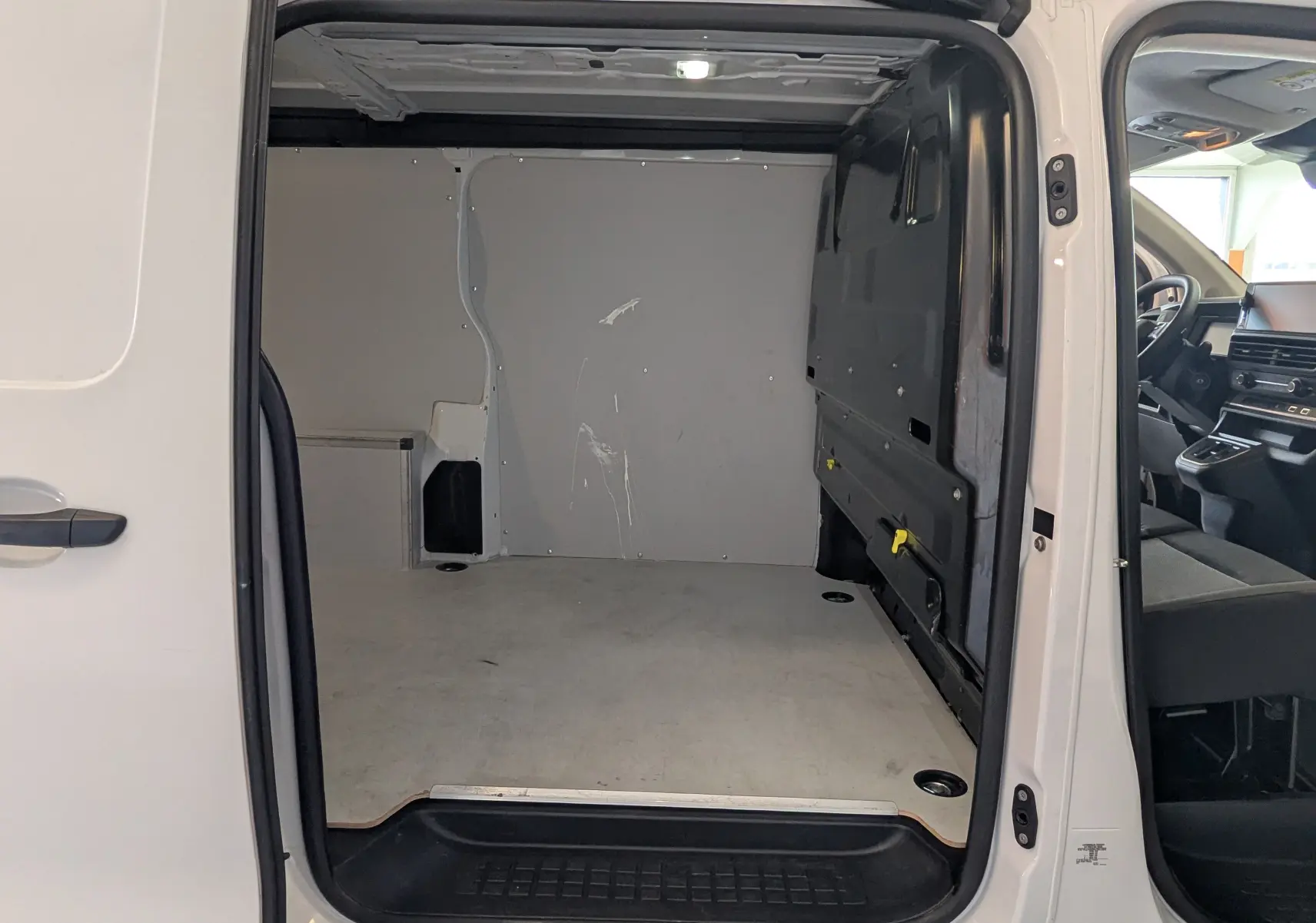 Vue intérieure du fourgon FIAT Scudo XL 145 EAT8 blanc, montrant l’espace de chargement vide et l’habitacle côté conducteur.