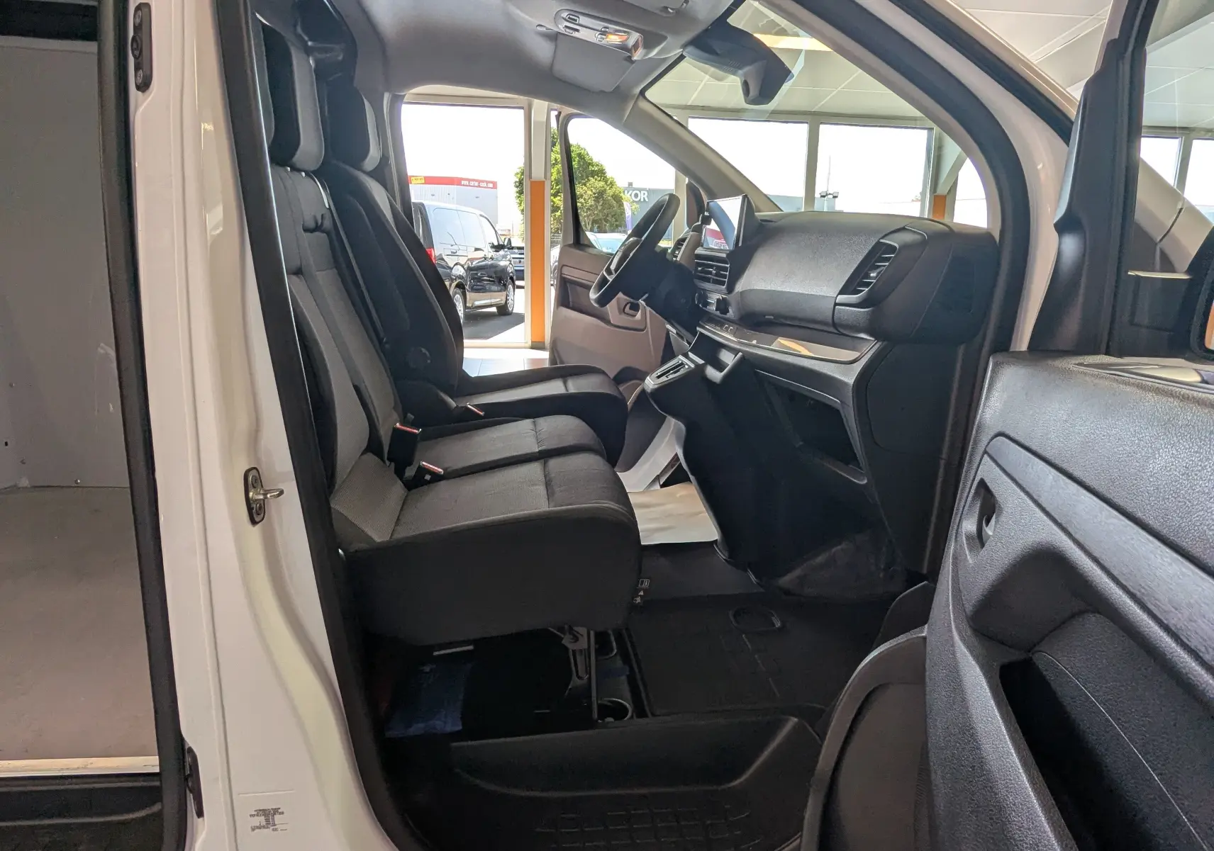 Vue intérieure côté gauche du FIAT Scudo Fourgon XL 145 EAT8 blanc 2024, montrant les sièges avant et le tableau de bord.