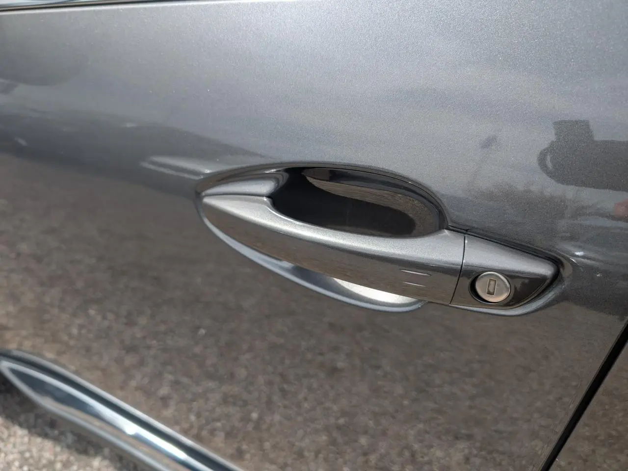 Poignée de porte côté droit gris métallisé du Peugeot 5008 2023 version GT avec serrure intégrée.