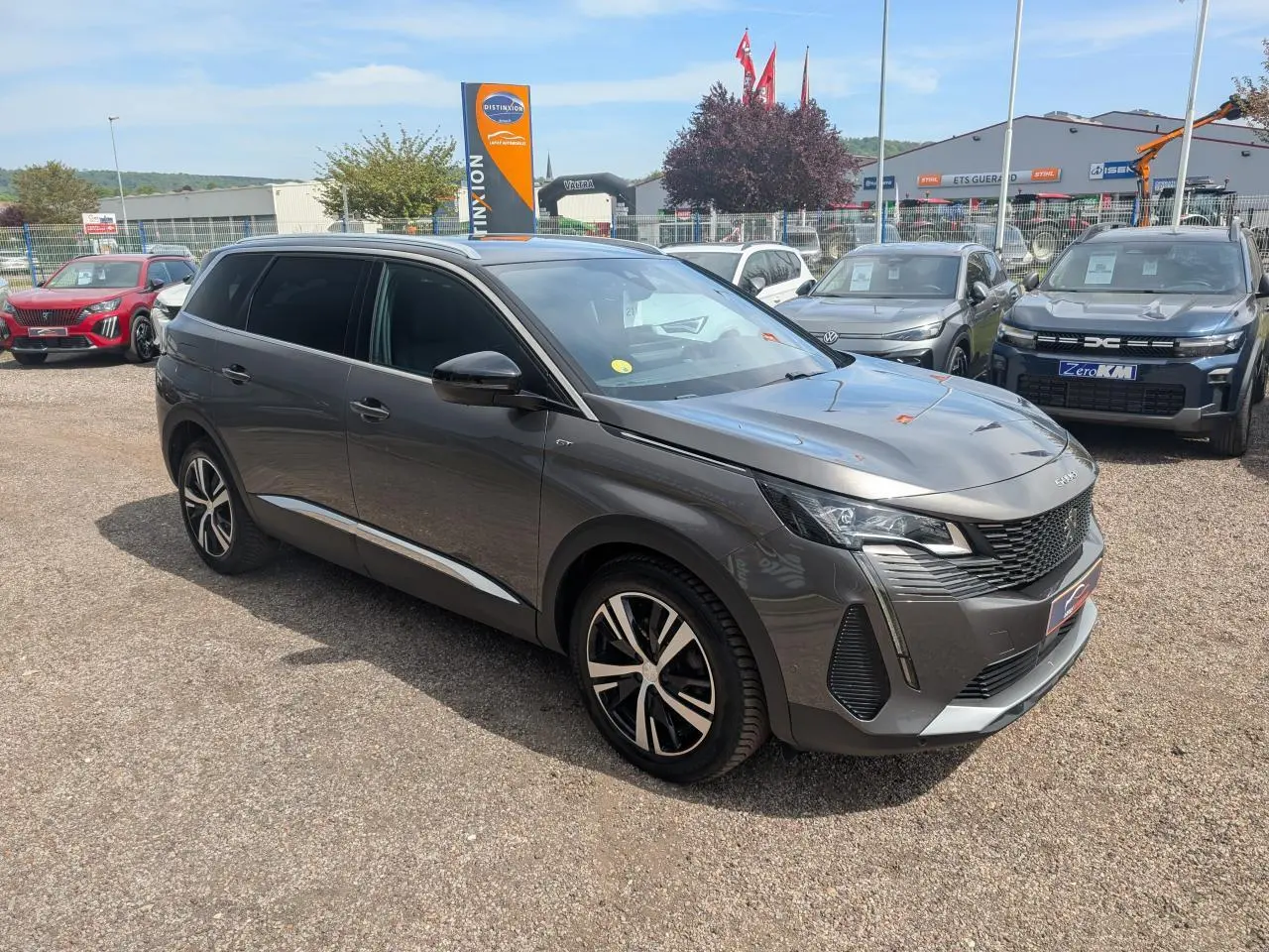 Peugeot 5008 gris métallisé vue 3/4 avant droit, calandre GT chromée et jantes alliage bi-ton 18 pouces.
