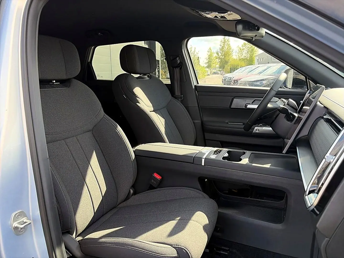 Intérieur avant du JAECOO J7 gris moonlight, vue côté gauche sur sièges tissu et console centrale avec écran tactile.
