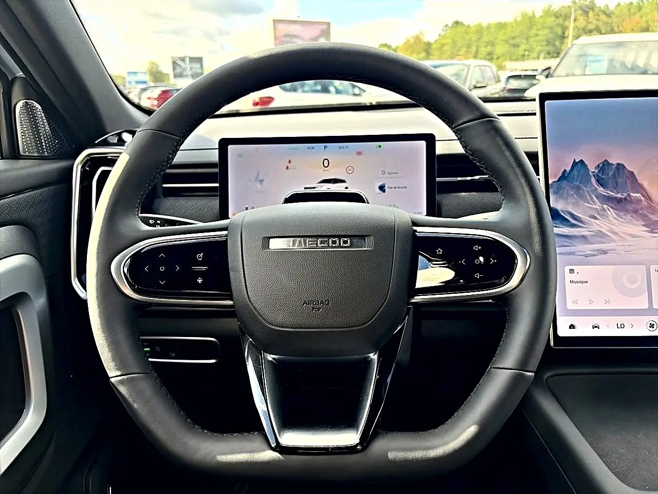 Vue intérieure centrée sur le volant noir du JAECOO J7 1.5 tgdi 224 select avec écran tactile et tableau de bord numérique.